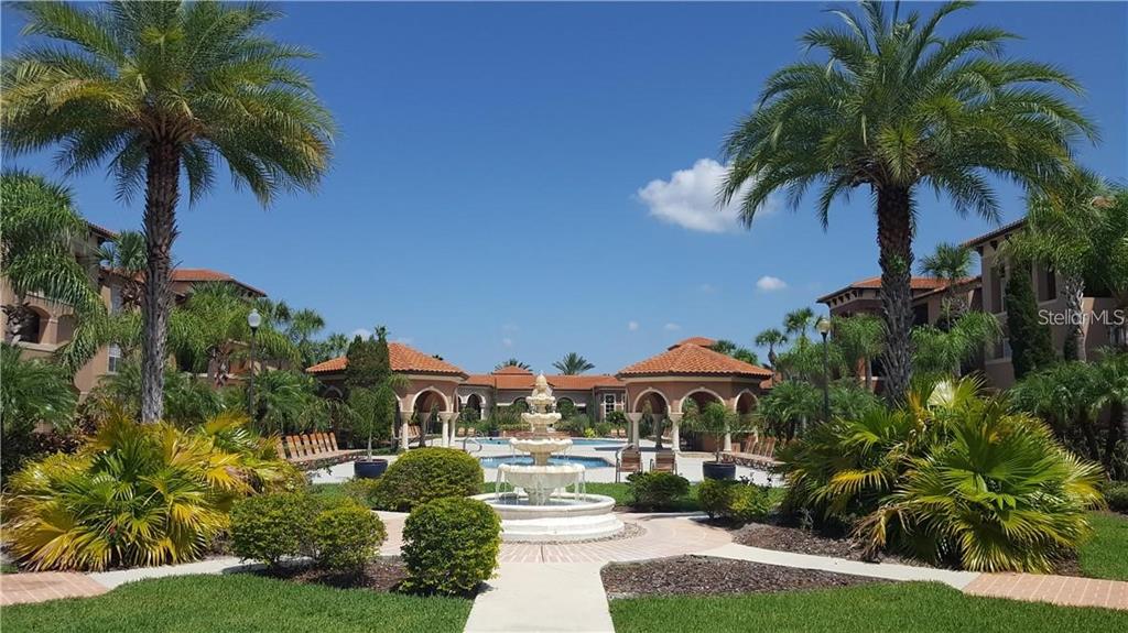 A courtyard features a tiered fountain, palm trees, and Mediterranean-style buildings with tiled roofs — 5554 METROWEST BOULEVARD UNIT 206, ORLANDO, FL
