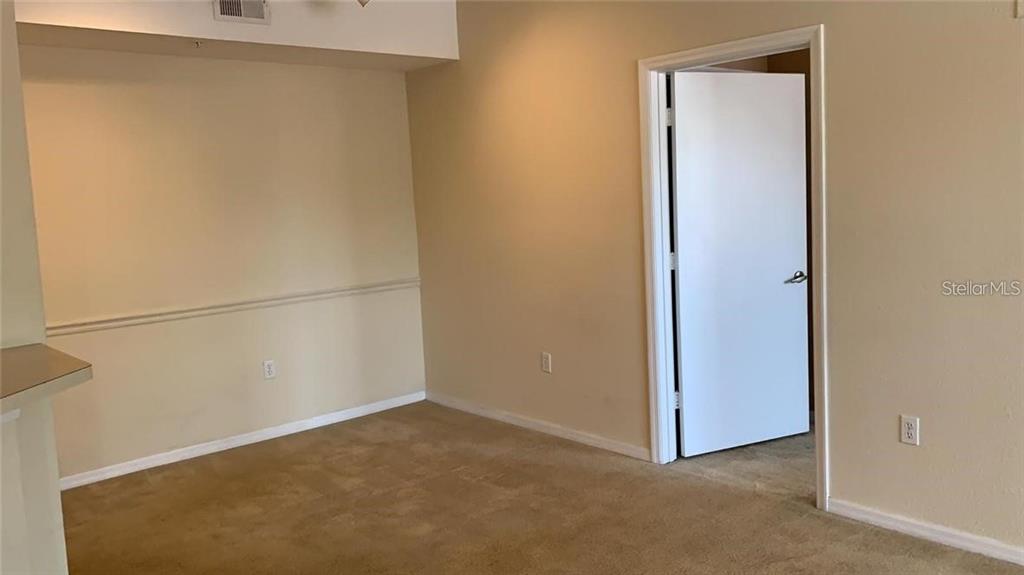 A carpeted room features beige walls, a chair rail, and an open doorway — 5554 METROWEST BOULEVARD UNIT 206, ORLANDO, FL