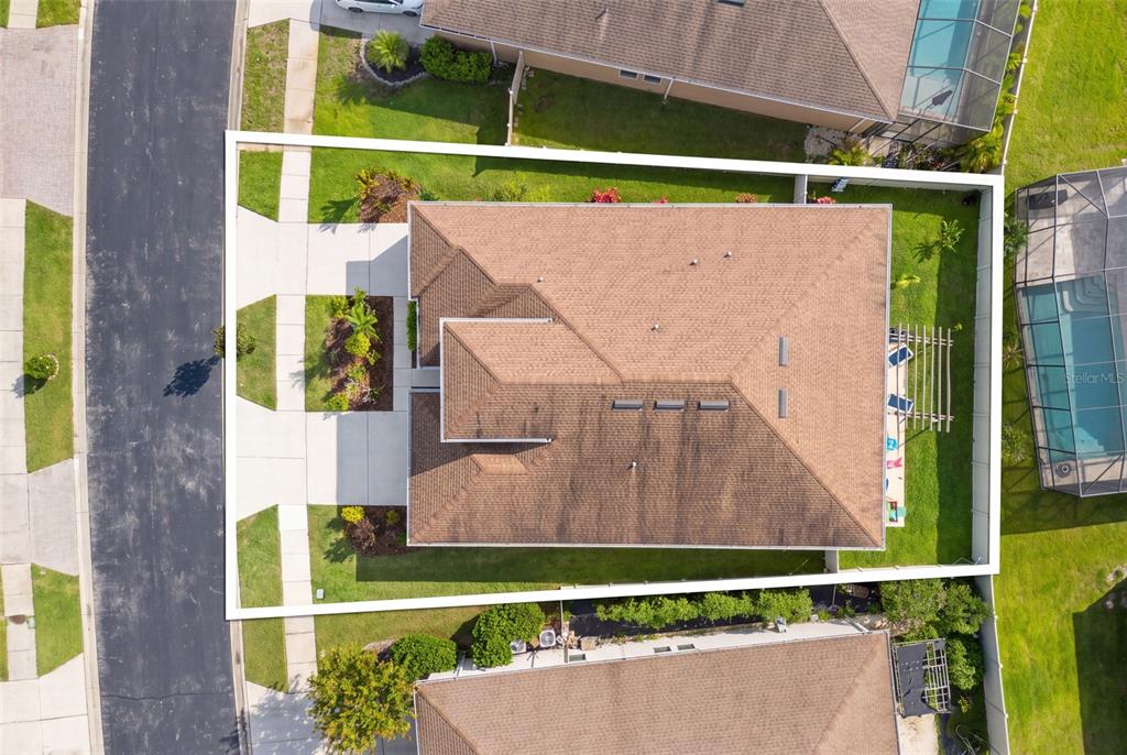 An aerial view shows a single-family home with a brown roof and a fenced yard — 1723 WHITEWILLOW DRIVE, WESLEY CHAPEL, FL