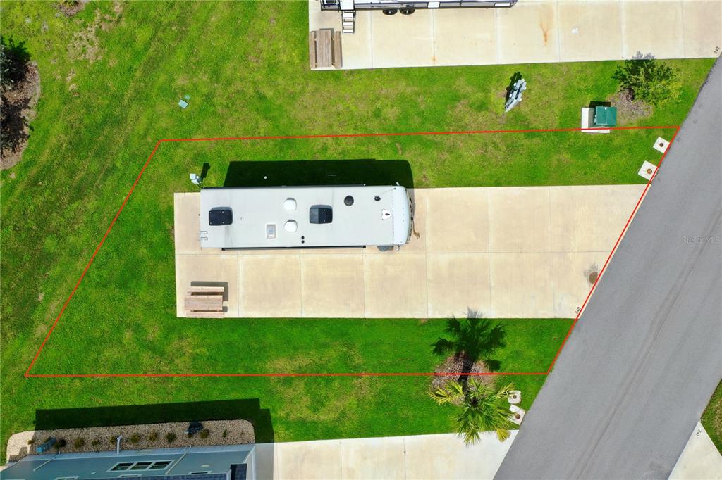 An aerial view shows a recreational vehicle parked on a concrete pad within a grassy lot — 240 HORIZON ROAD, PUNTA GORDA, FL