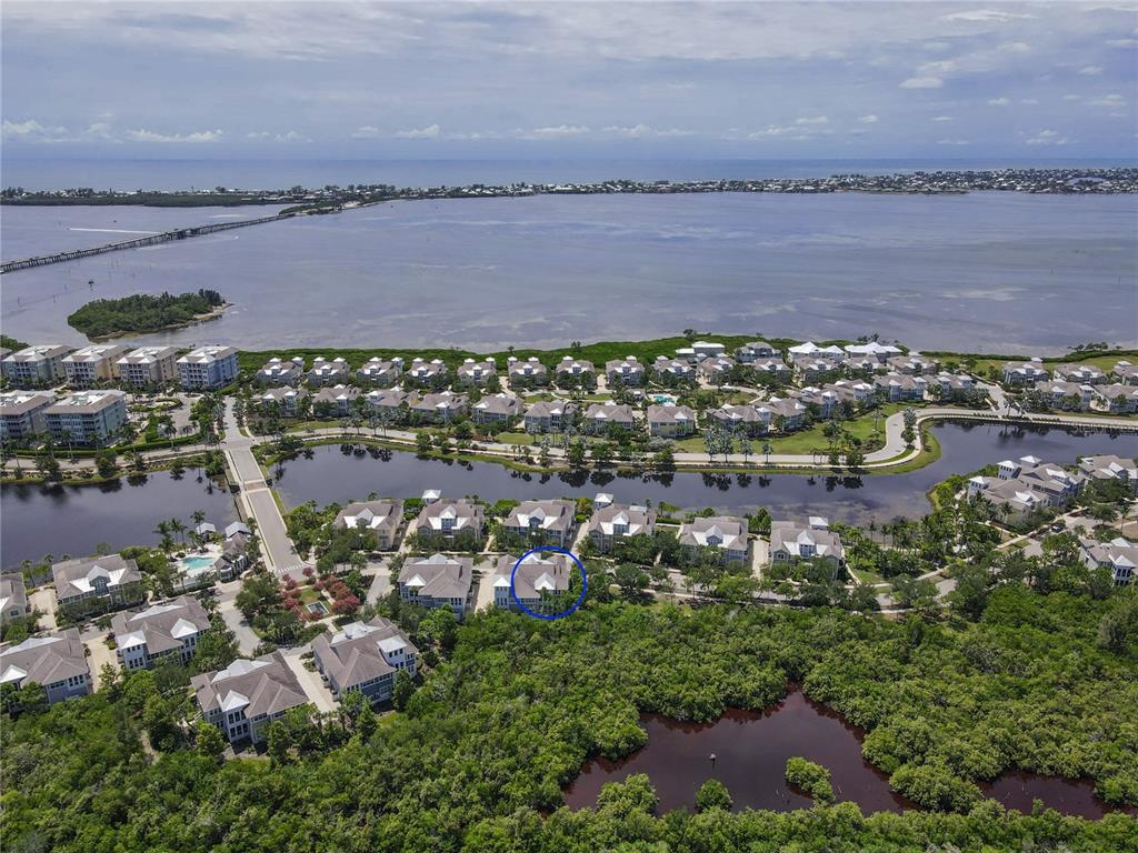 An aerial view shows a residential community with a blue circle highlighting a specific building — 311 SAPPHIRE LAKE DRIVE UNIT 202, BRADENTON, FL