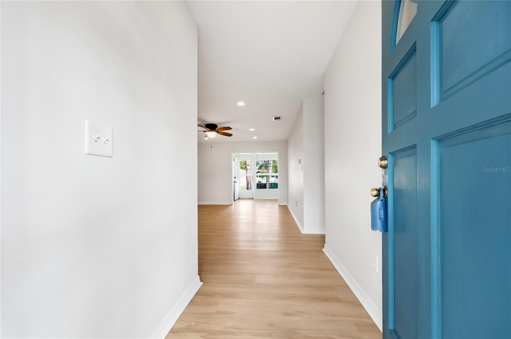 A single-story white house with blue shutters and a concrete walkway leading to the entrance — 249 N HILL AVENUE UNIT 30, DELAND, FL