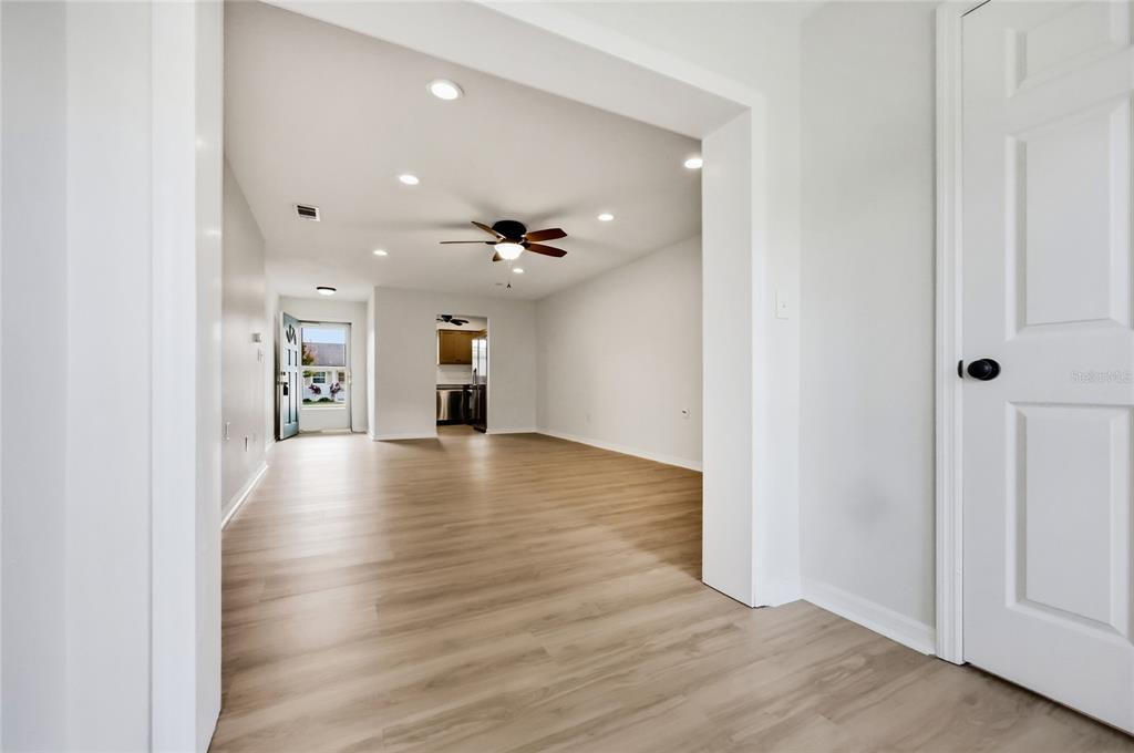 A bright entryway features light wood-look flooring, a white door, and a large window — 249 N HILL AVENUE UNIT 30, DELAND, FL