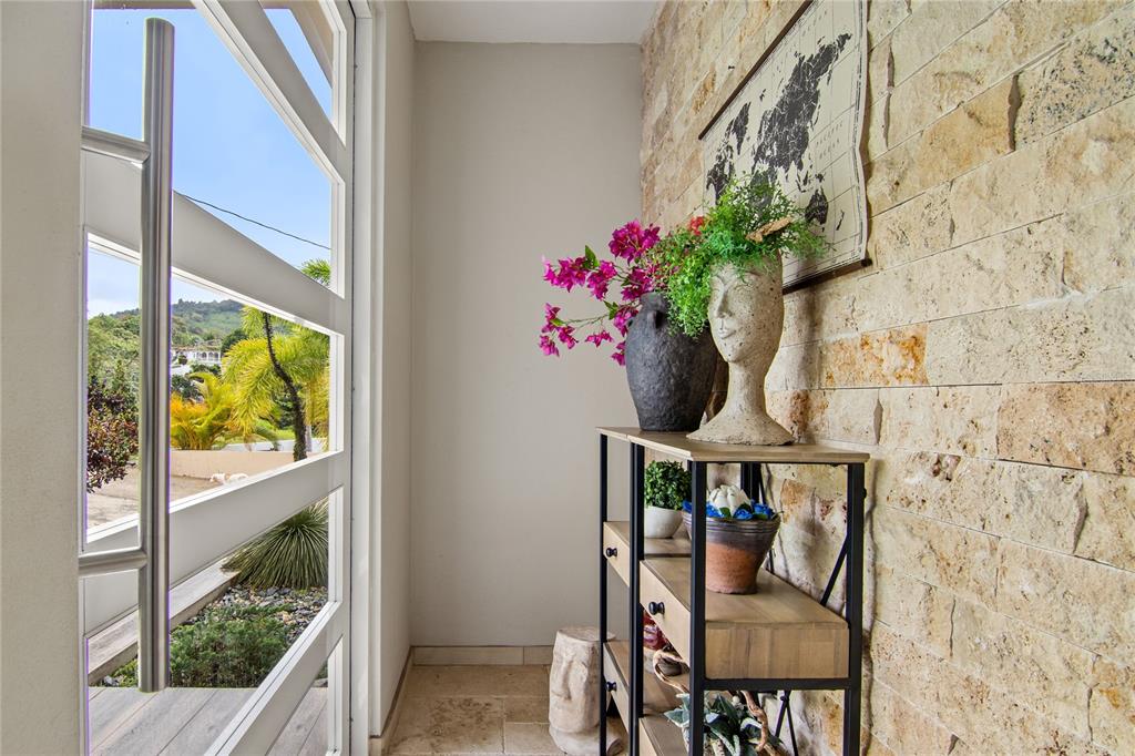 An entryway features a stone accent wall, a decorative console table, and a glass door — PR 757 KM 1.7 INT LOT 4 LA CEIBA POLLOS WARD, PATILLAS, PR