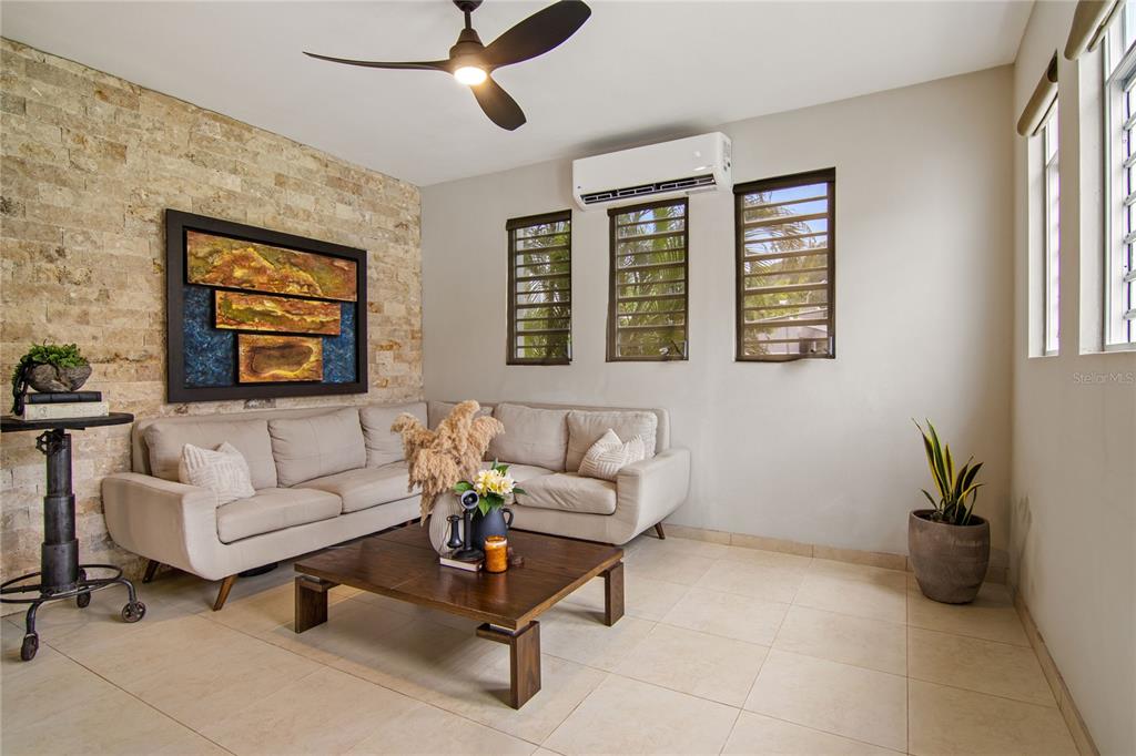 A living room features a stone accent wall, a beige sectional sofa, and louvered windows — PR 757 KM 1.7 INT LOT 4 LA CEIBA POLLOS WARD, PATILLAS, PR