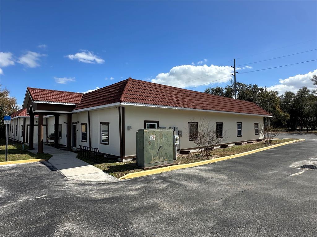 An exterior view of a single-story building with a red tiled roof and parking lot — 401 E NORTH BOULEVARD UNIT 101/103, LEESBURG, FL