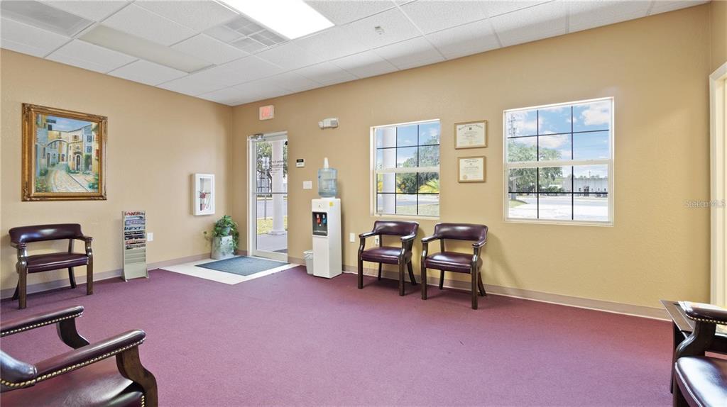 A waiting room with purple carpet, tan walls, several chairs, and a water cooler — 401 E NORTH BOULEVARD UNIT 101/103, LEESBURG, FL