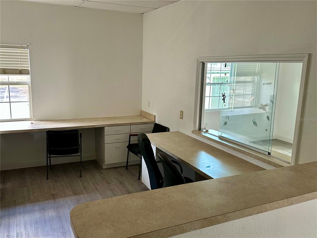 An office room features two built-in desks, a window, and light-colored wood-look flooring — 401 E NORTH BOULEVARD UNIT 101/103, LEESBURG, FL