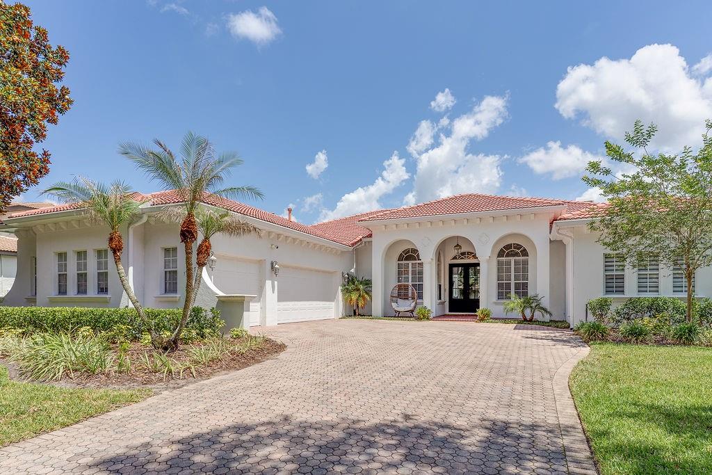 A single-story Mediterranean-style house with a red tile roof and a paved driveway — 11027 HAWKSHEAD COURT, WINDERMERE, FL