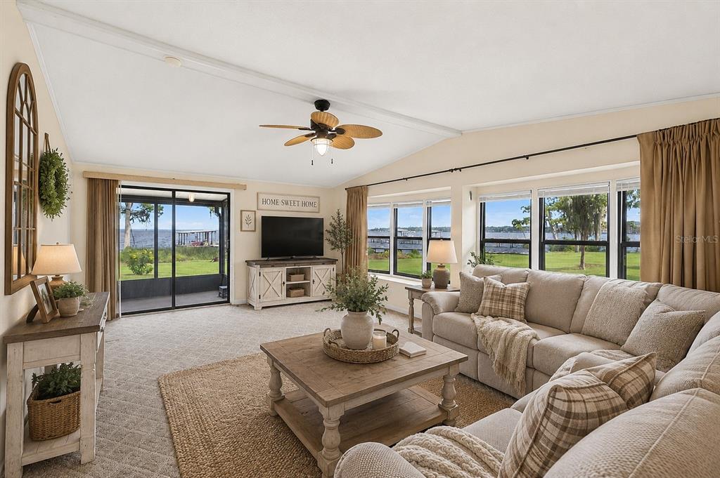 A kitchen with oak cabinets and a center island overlooks a lake through sliding doors — 311 POMONA LANDING ROAD, CRESCENT CITY, FL