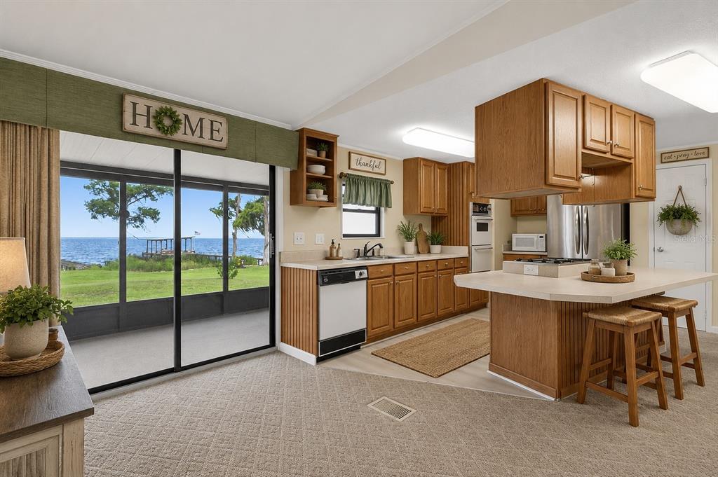 A living room features wood-paneled walls, a built-in bar, and a carpeted floor — 311 POMONA LANDING ROAD, CRESCENT CITY, FL