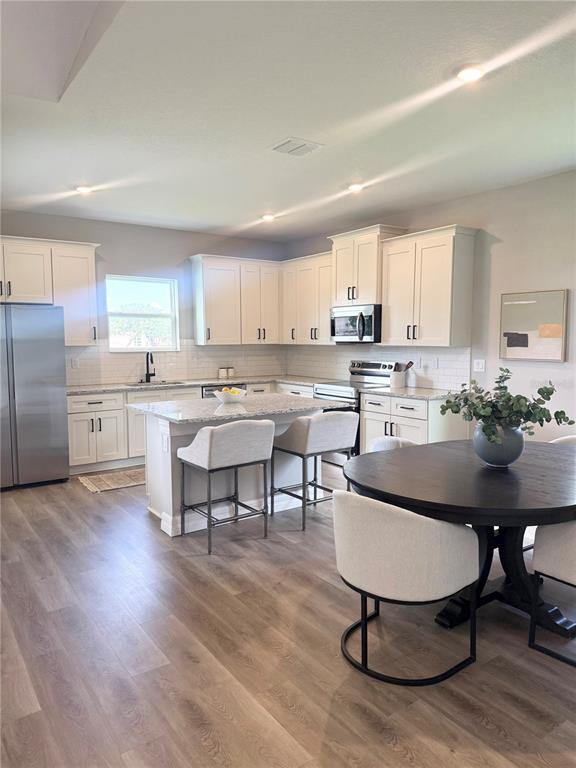 A single-story house with a beige stucco exterior, stone accents, and a paved driveway — 4329 CREMONA DRIVE, SEBRING, FL