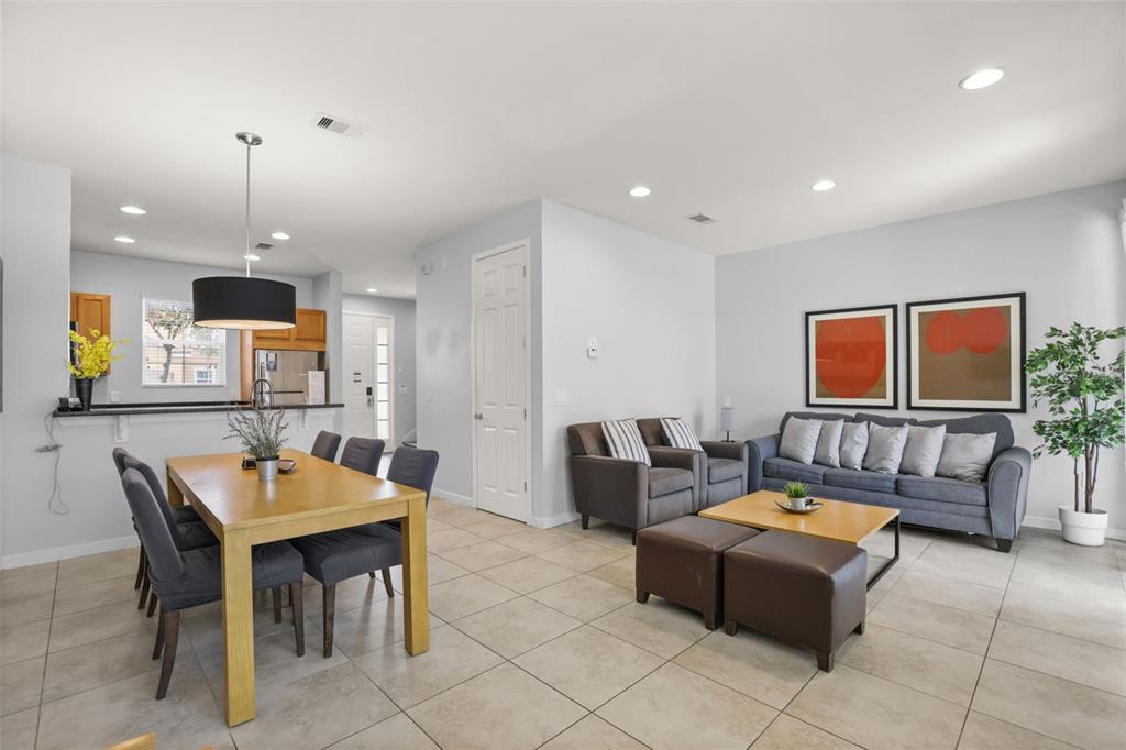 The exterior of an orange stucco townhouse features a covered entryway with a white door — 2702 CORVETTE LANE, KISSIMMEE, FL