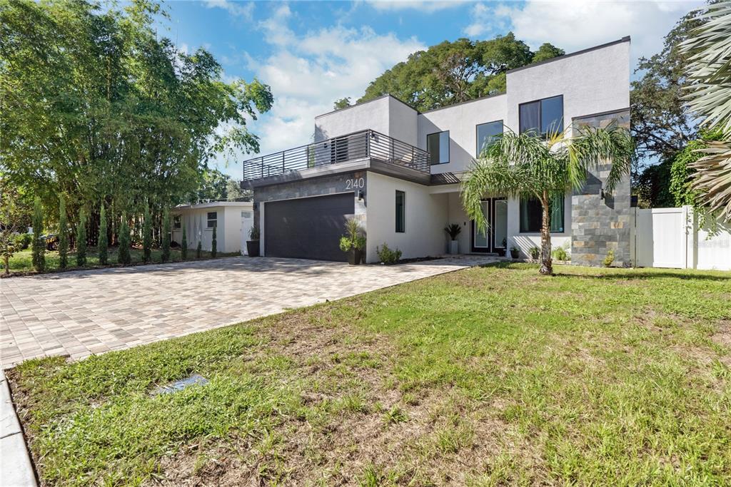 A modern two-story house with a flat roof, stone accents, and a paved driveway — 2140 CATALINA DRIVE, CLEARWATER, FL