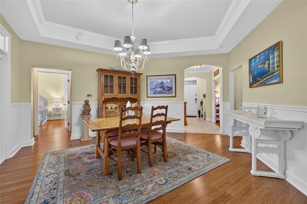 A dining room with a wooden table, chairs, hutch, and a patterned area rug — 1411 CELEBRATION AVENUE UNIT 103, CELEBRATION, FL