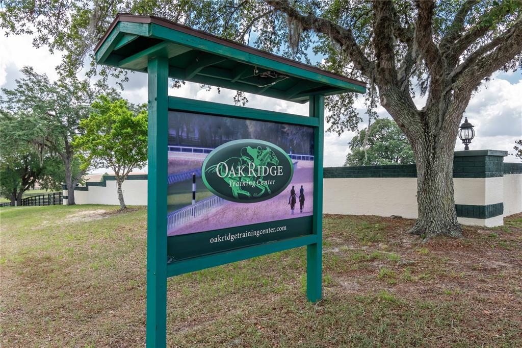 A green wooden sign for Oak Ridge Training Center stands on a grassy lawn — 3670 SE 148TH TERRACE, MORRISTON, FL