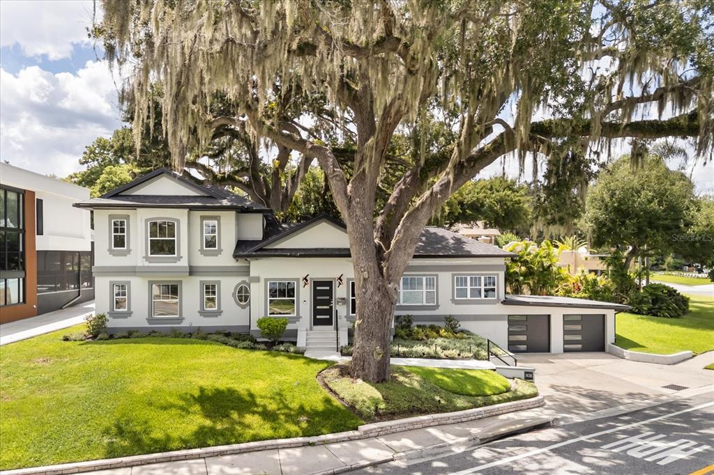 A two-story house with a large oak tree in the front yard and a garage — 808 EDGEWATER DRIVE, ORLANDO, FL