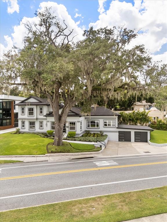 A two-story house with a large oak tree in the front yard and attached garage — 808 EDGEWATER DRIVE, ORLANDO, FL