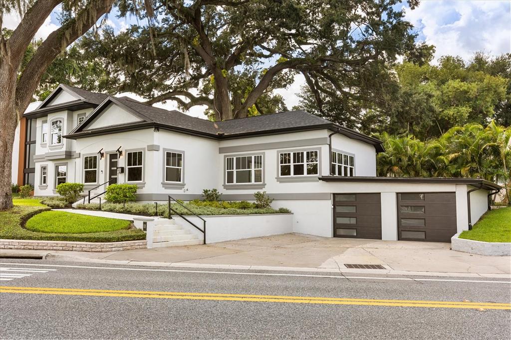 A white house with gray trim, a two-car garage, and a large tree in front — 808 EDGEWATER DRIVE, ORLANDO, FL