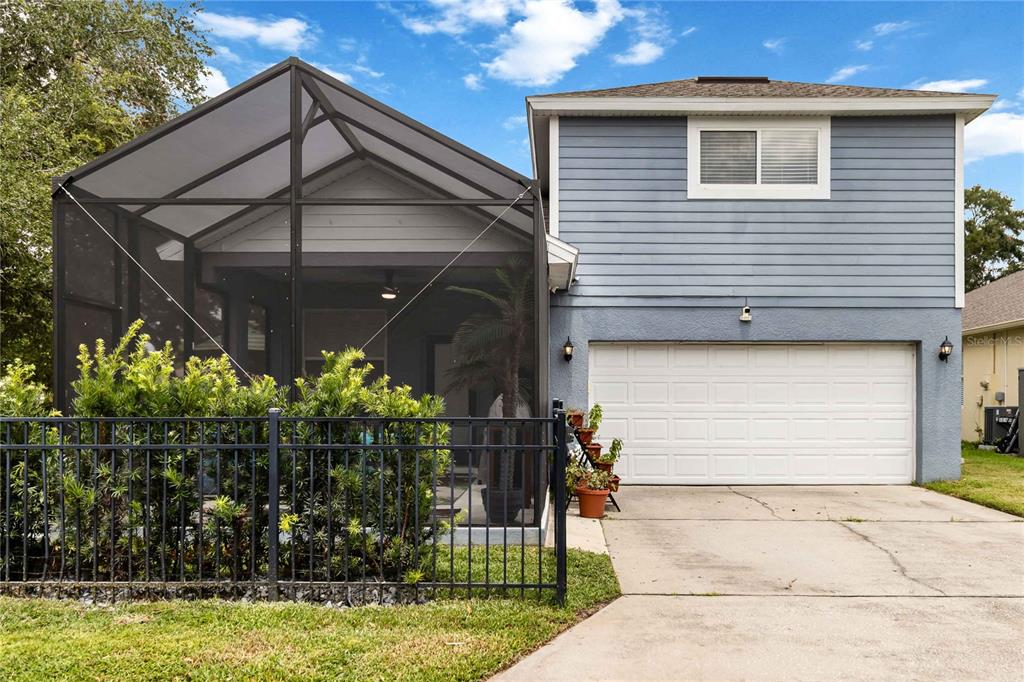 A two-story house with a screened-in patio, a white garage door, and a concrete driveway — 880 SUMMER OAKS ROAD, WINTER GARDEN, FL