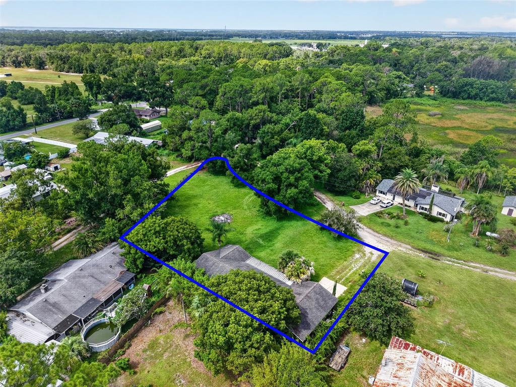 An aerial view shows a house with a large yard outlined in blue — 37320 BEACH DR, UMATILLA, FL