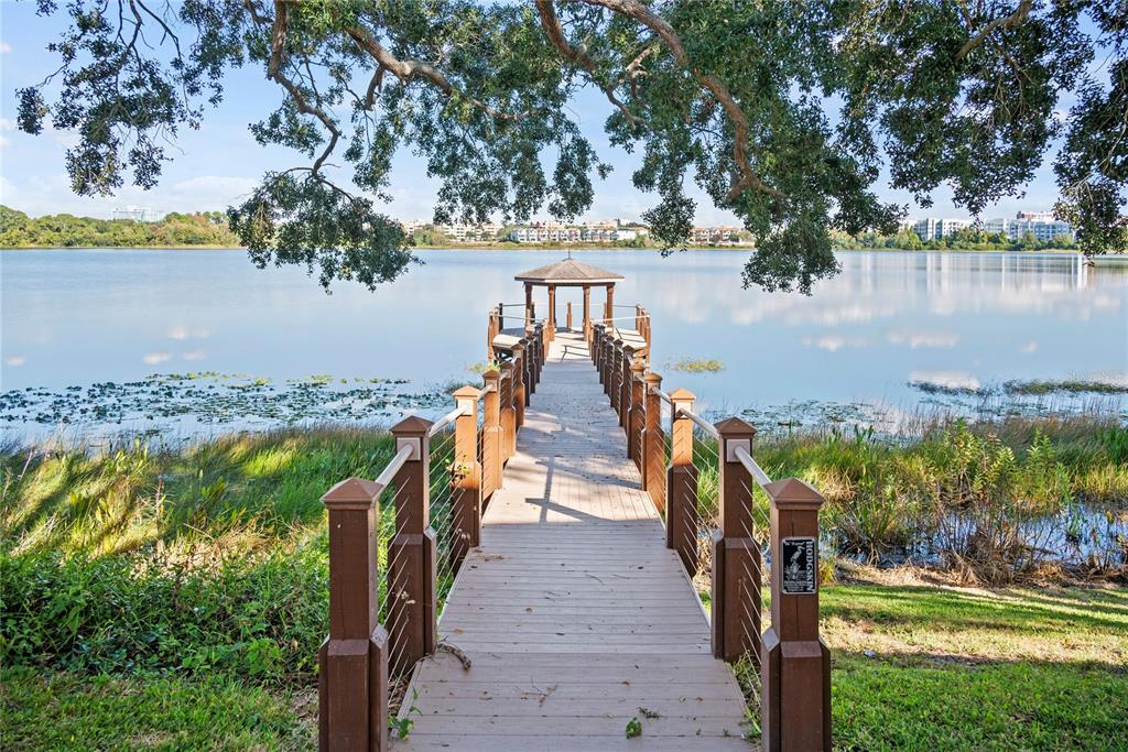 A wooden pier with a gazebo extends over a lake under a large tree — 7319 SOMERSET SHORES COURT, ORLANDO, FL