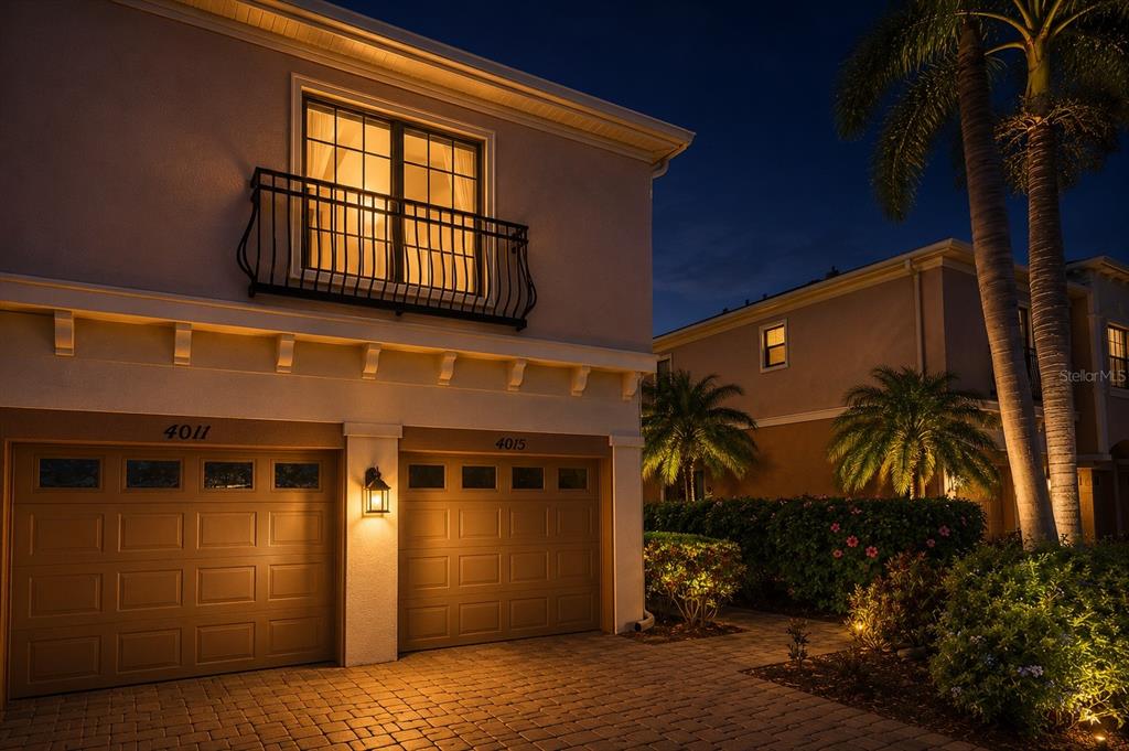 Exterior view of a two-story house at night with two garage doors and a balcony — 4015 OVERTURE CIRCLE UNIT 314, BRADENTON, FL