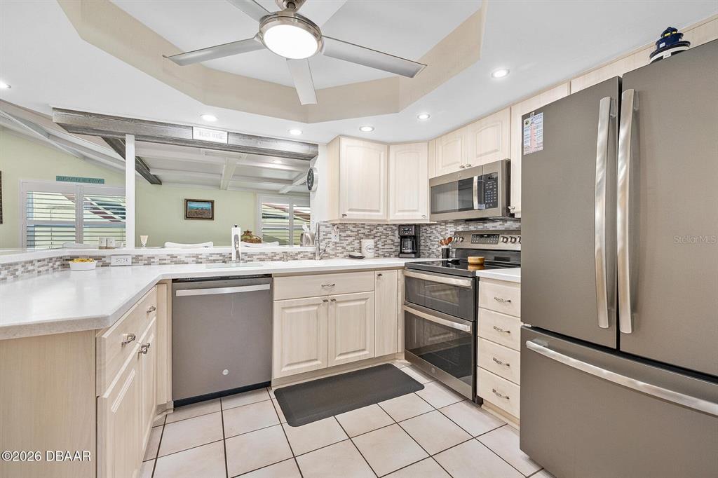 A kitchen features light wood cabinets, stainless steel appliances, and a tiled floor — 4708 DIXIE DRIVE, PONCE INLET, FL