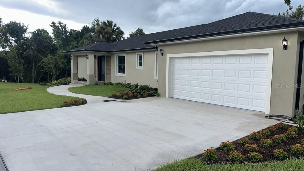 The exterior of a house features a covered entryway with wood-look tile and a dark door — 4880 BARNA AVENUE, TITUSVILLE, FL