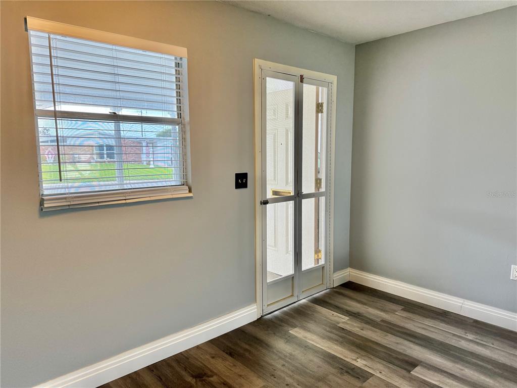 A living room features a black leather sofa, wood coffee table, and a teal accent wall — 2217 HOPKINS DRIVE W UNIT 2217, BRADENTON, FL