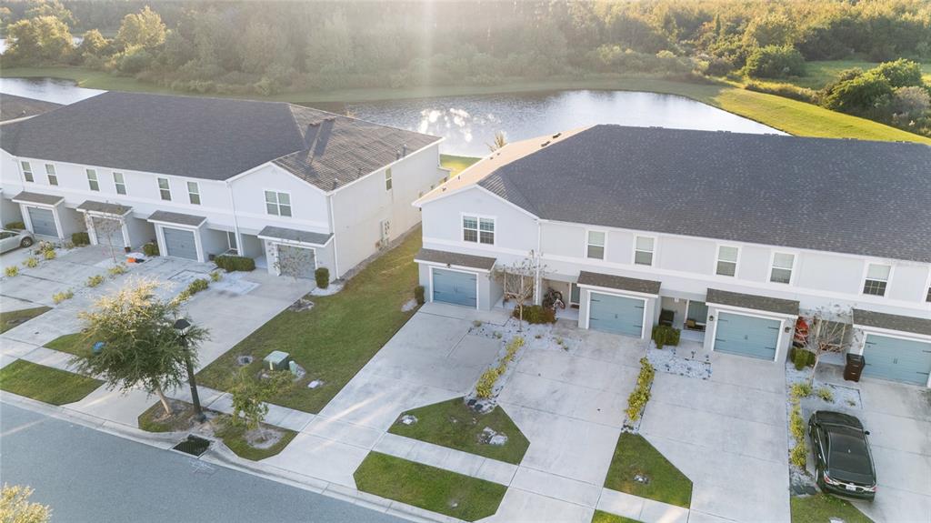 An aerial view shows two rows of multi-unit townhomes with driveways facing a street — 2922 FIELDWOOD CIRCLE, ST CLOUD, FL