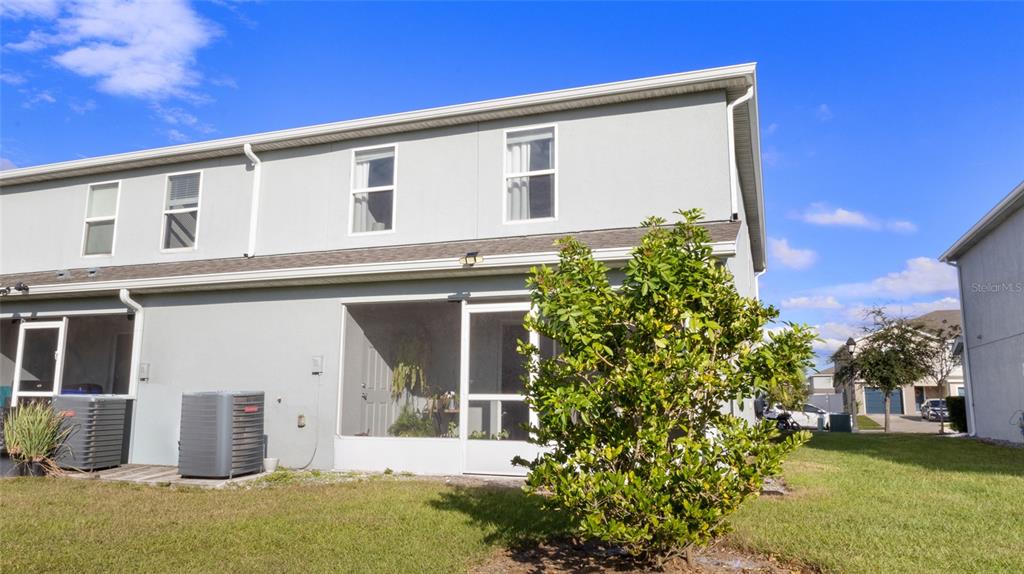The exterior of a two-story townhouse features a screened-in patio and two air conditioning units — 2922 FIELDWOOD CIRCLE, ST CLOUD, FL