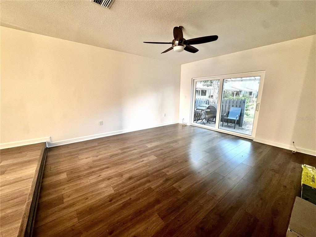 A concrete patio with a metal awning sits outside a sliding glass door — 1134 RUE DES ROIS UNIT 1134, ST PETERSBURG, FL
