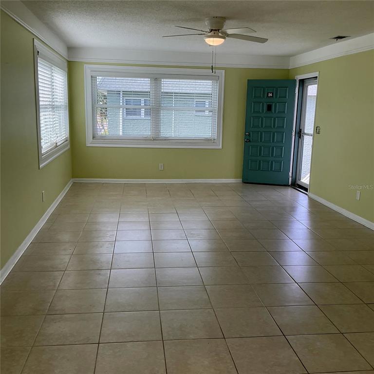 A two-story apartment building exterior features white stucco walls, green trim, and an outdoor staircase — 5267 81ST ST N UNIT 26, ST PETERSBURG, FL