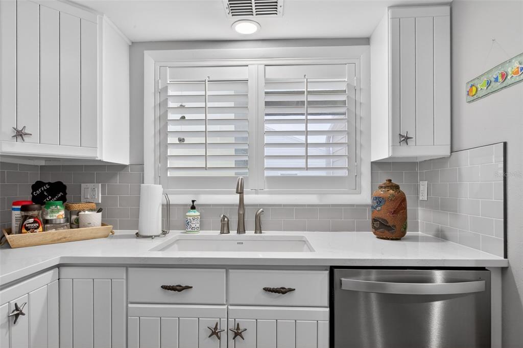 A bathroom features a white vanity, a toilet, a wall-mounted shelf, and plantation shutters — 6300 A1A S UNIT B24U, ST AUGUSTINE, FL