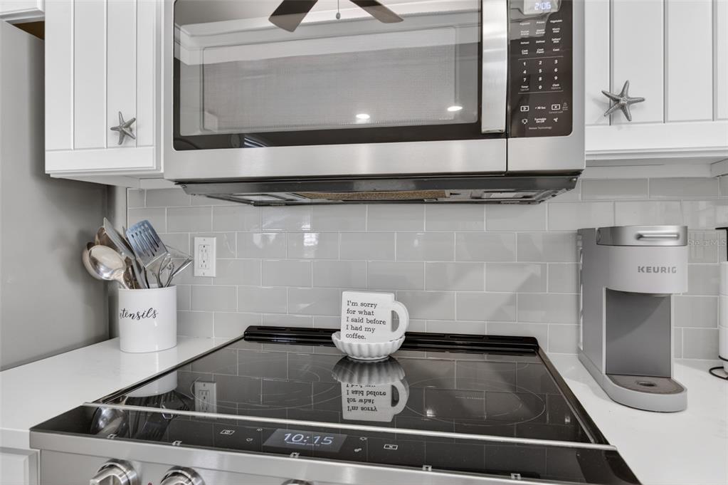 A coastal-themed living and dining area features gray walls, carpeted floors, and a white ladder — 6300 A1A S UNIT B24U, ST AUGUSTINE, FL