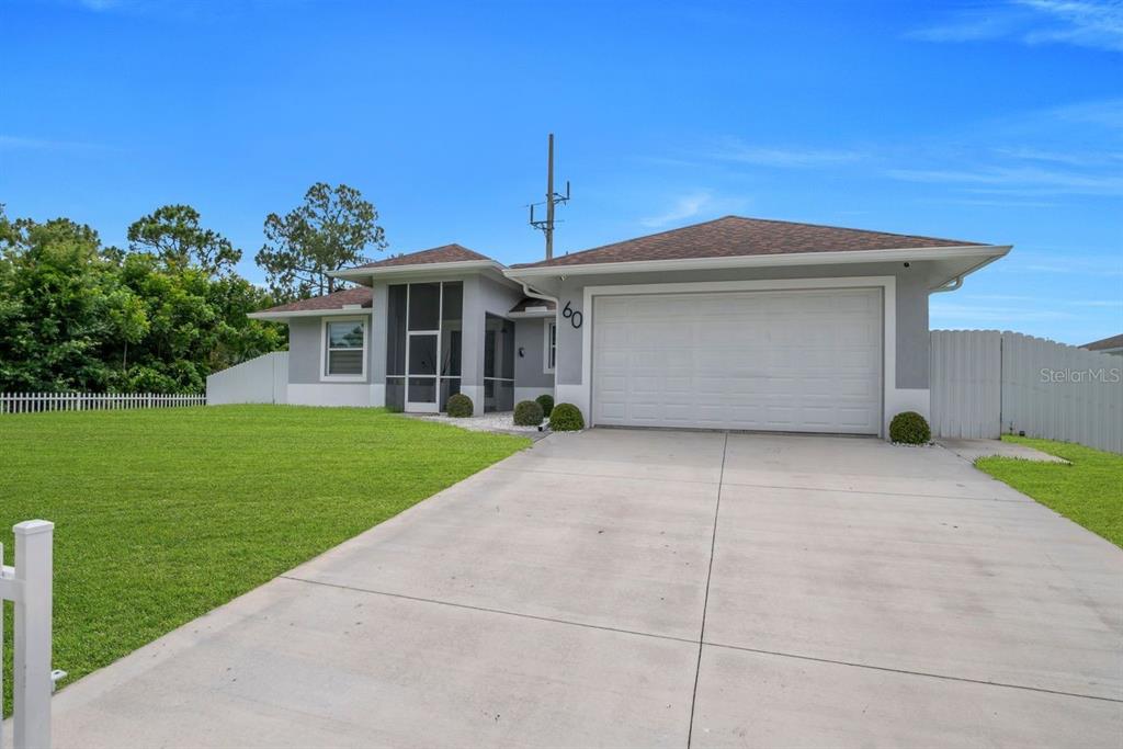 A gray single-story house features a two-car garage, a screened entryway, and a concrete driveway — 60 FLOYD AVENUE S, LEHIGH ACRES, FL
