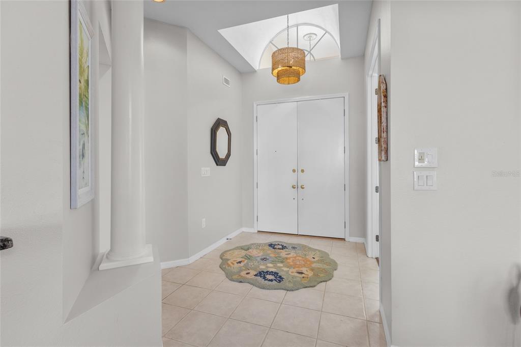 A living room features wood flooring, a ceiling fan, a television, and a sliding glass door — 6774 PASEO CASTILLE, SARASOTA, FL
