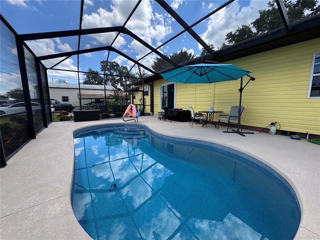 A yellow house with a front porch and a paved walkway sits on a lawn — 398 VIRGINIA STREET, FROSTPROOF, FL