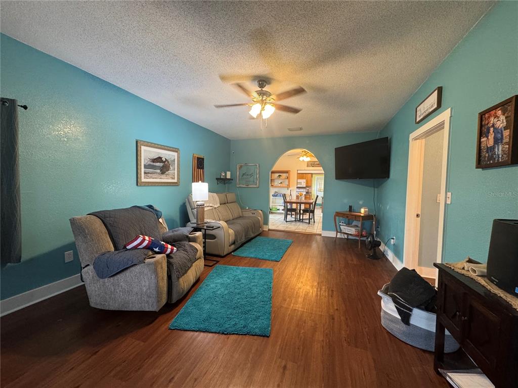 A screened-in patio features a kidney-shaped swimming pool and a blue cantilever umbrella — 398 VIRGINIA STREET, FROSTPROOF, FL