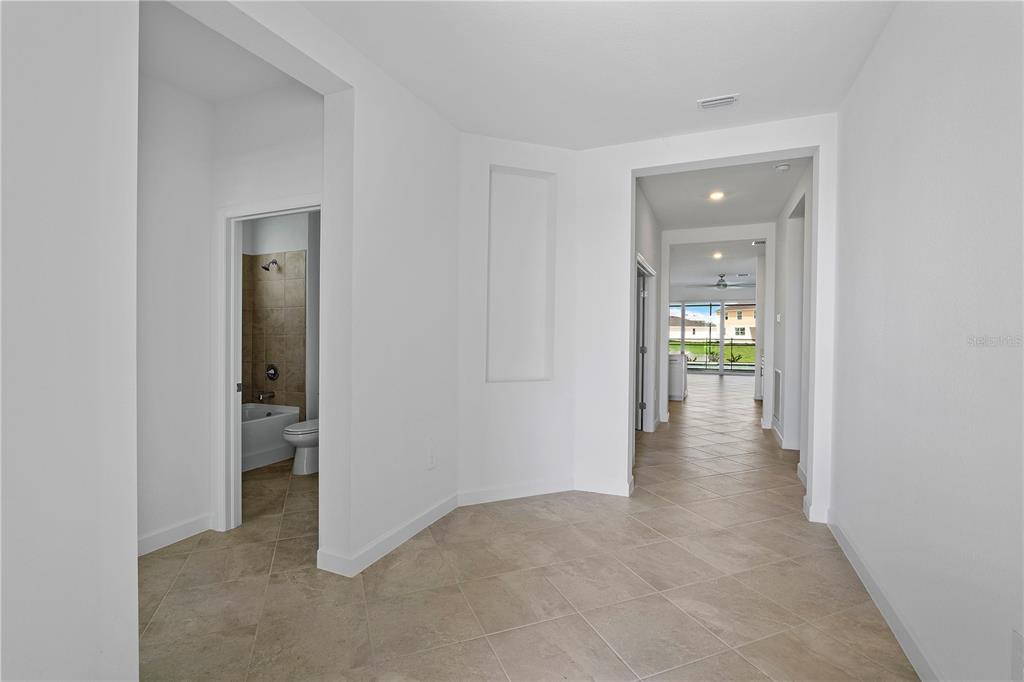 A tiled hallway leads to a living area with a view of a neighboring house — 15078 WHITE PEARL ROAD, PUNTA GORDA, FL