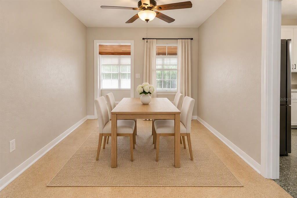A room with beige walls, a ceiling fan, and speckled flooring leads to a sunroom — 206 S WESTSHORE BOULEVARD, TAMPA, FL