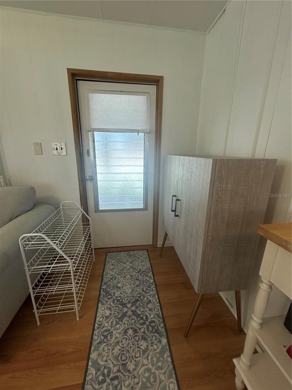 An entryway features a white door, a wire shoe rack, a patterned runner, and a cabinet — 1874 PALM SPRINGS STREET, SARASOTA, FL