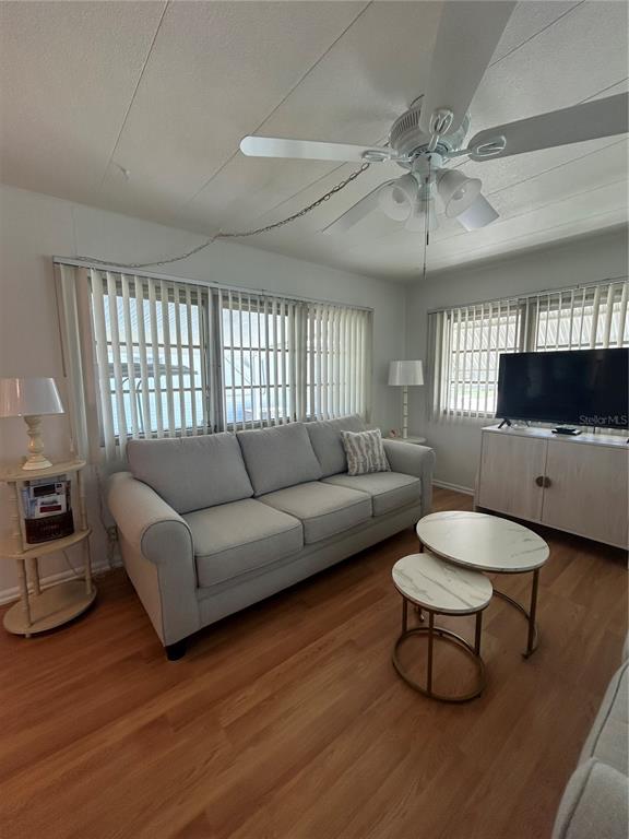 A living room features a light gray sofa, nesting coffee tables, and a ceiling fan — 1874 PALM SPRINGS STREET, SARASOTA, FL