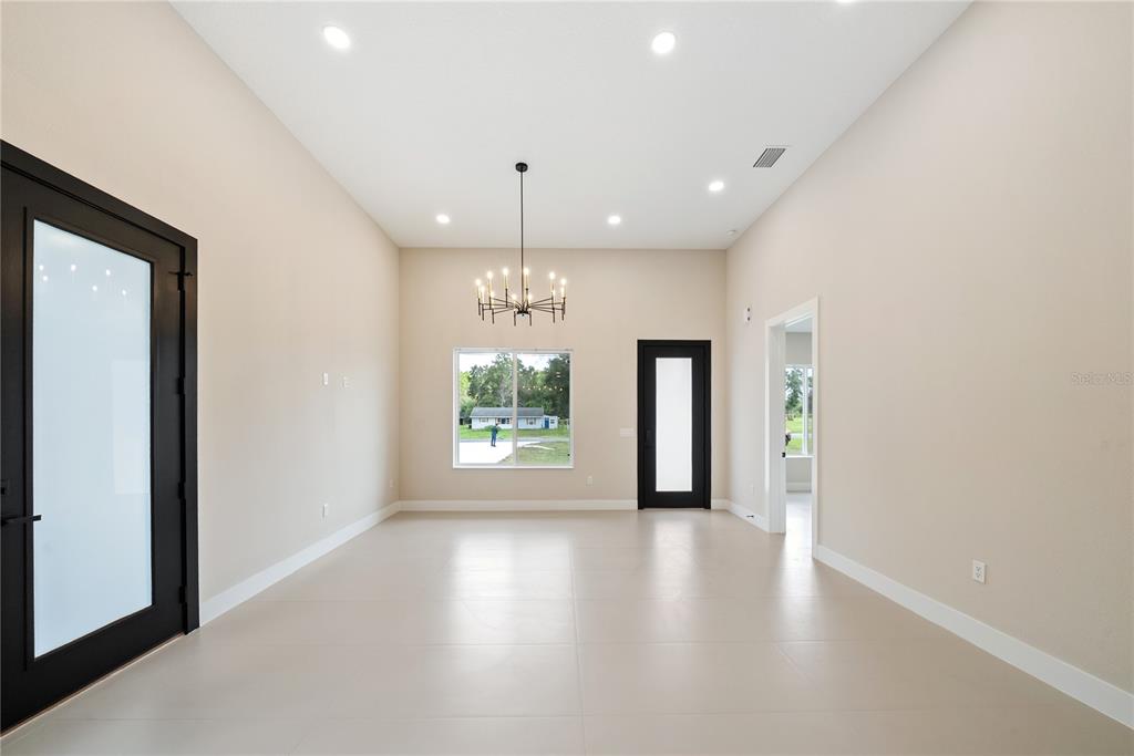 A modern bathroom features a wood vanity, white countertop, black fixtures, and a glass-enclosed shower — 12352 SW 61ST PLACE ROAD, OCALA, FL