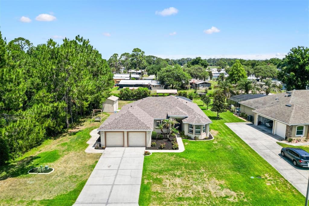 A spacious living room features tile flooring, vaulted ceilings, two ceiling fans, and leather furniture — 12107 EAGLE POINT COURT, LEESBURG, FL