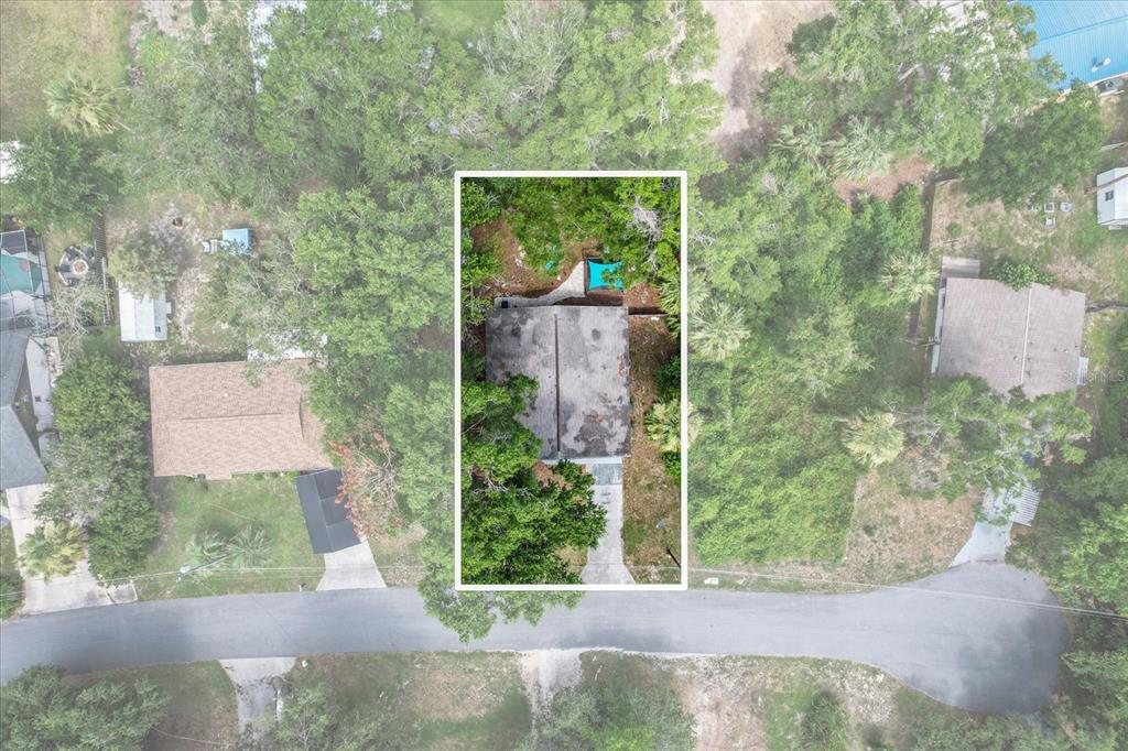 An aerial view shows a house with a gray roof surrounded by trees and greenery — 4080 N EAGLE NEST POINT, CRYSTAL RIVER, FL