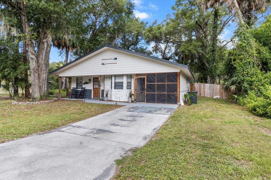 A single-story house with a screened porch, white siding, and a concrete driveway — 4080 N EAGLE NEST POINT, CRYSTAL RIVER, FL