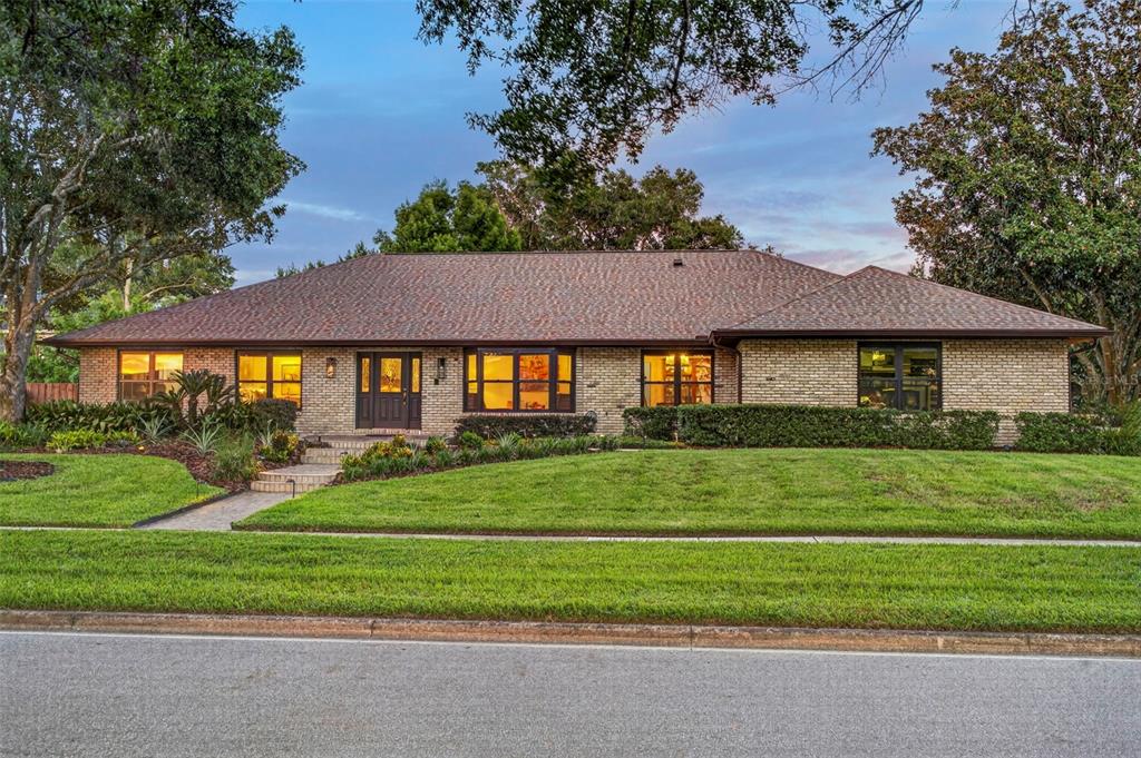 A single-story brick house with a brown shingled roof, front lawn, and mature trees — 1281 WELLINGTON TERRACE, MAITLAND, FL