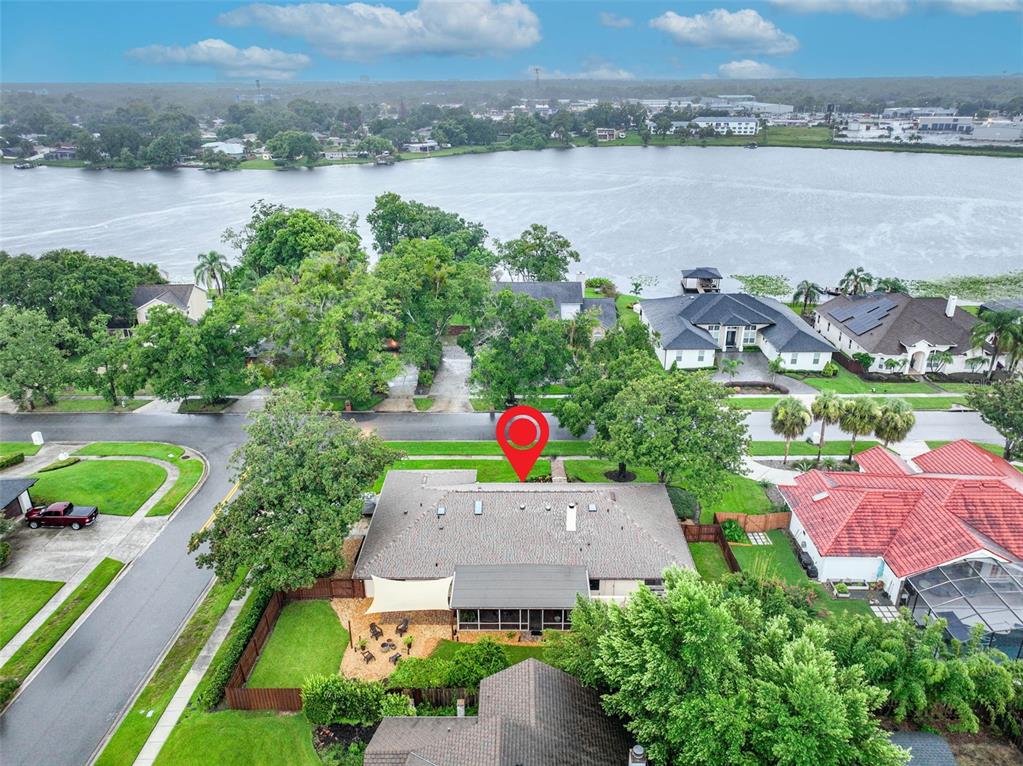 An aerial view shows a residential house with a fenced backyard and a nearby lake — 1281 WELLINGTON TERRACE, MAITLAND, FL